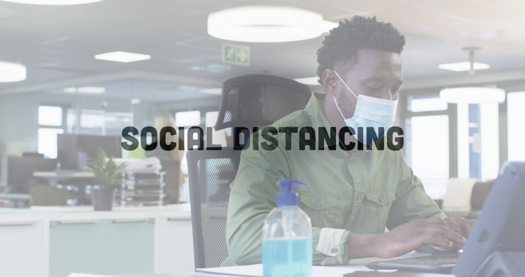 Man Wearing Face Mask Working on Laptop in Office