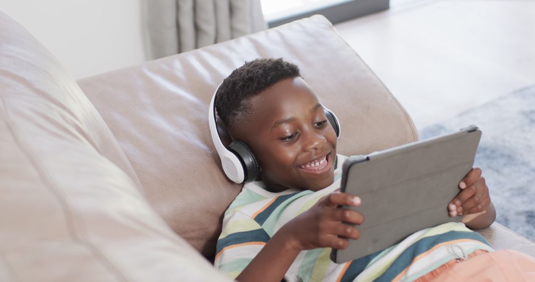 Smiling Boy with Headphones Enjoying Tablet at Home