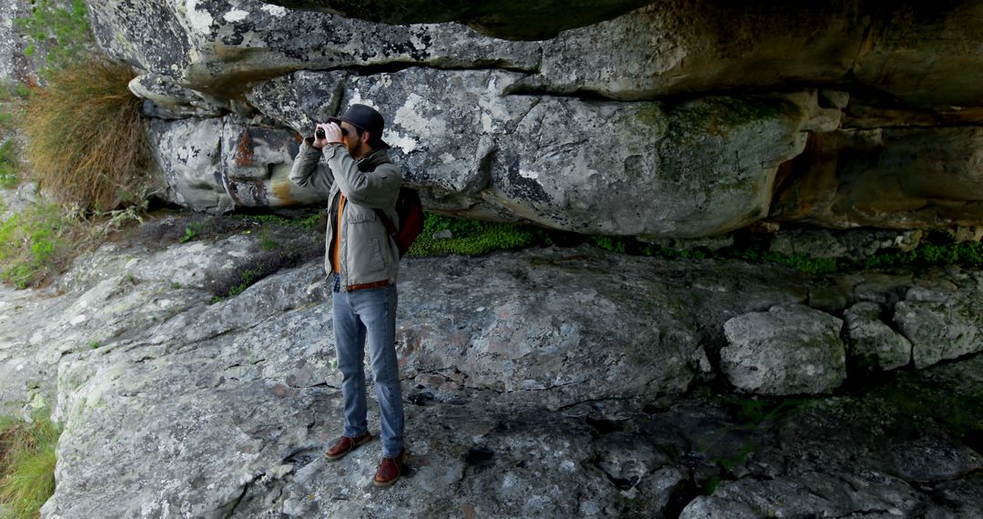 Hiker Exploring Cave with Binoculars - Free Images, Stock Photos and Pictures on Pikwizard.com