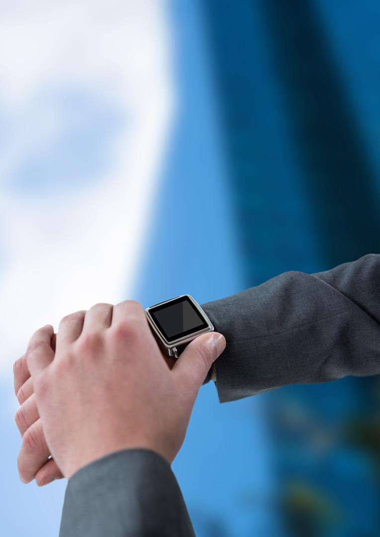 Businessman Checking Smartwatch with Modern Building Background - Free Images, Stock Photos and Pictures on Pikwizard.com