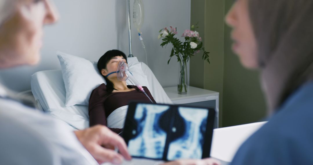 Doctor and nurse examining patient with oxygen mask and x-ray film in hospital room - Free Images, Stock Photos and Pictures on Pikwizard.com