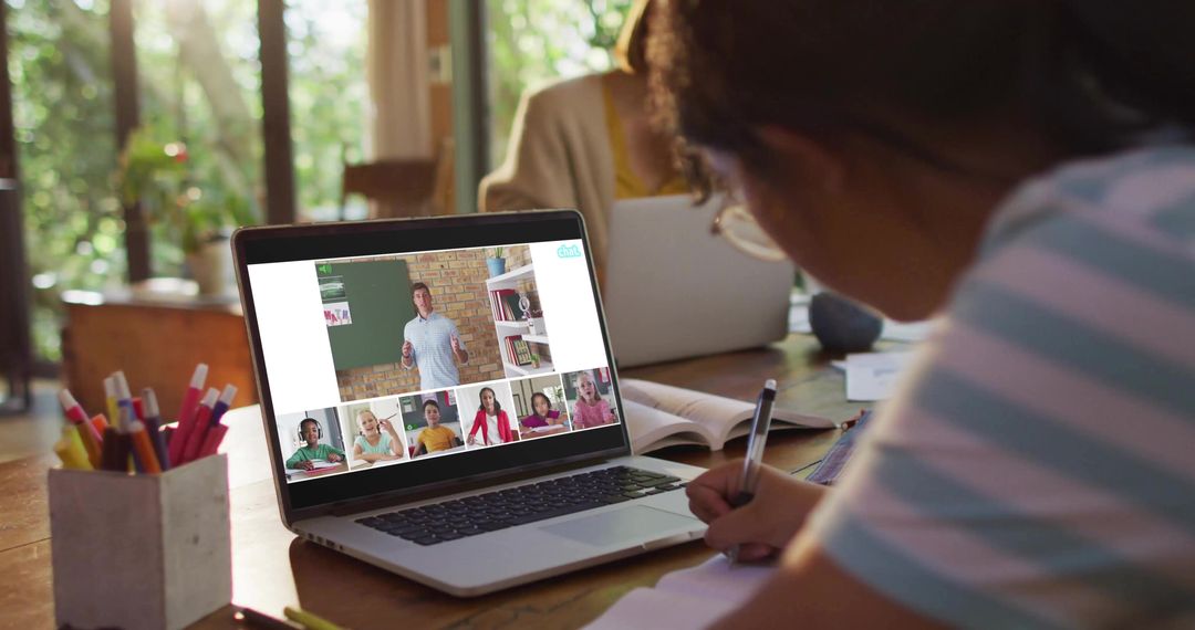 Child Studying Online at Home Taking Notes During Virtual Classroom and Remote Learning