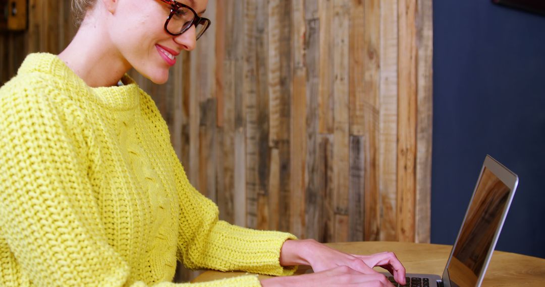 Young Woman Smiling While Typing on Laptop in Cozy Setting - Free Images, Stock Photos and Pictures on Pikwizard.com