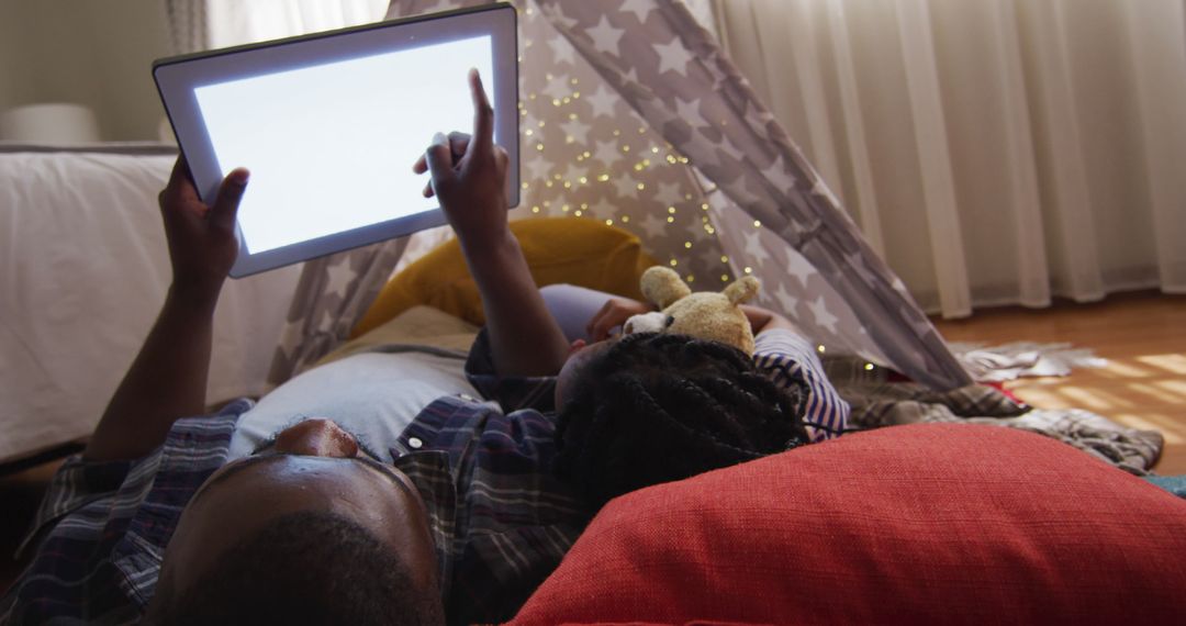 Father and Daughter Bonding with Tablet in Cozy Tent at Home