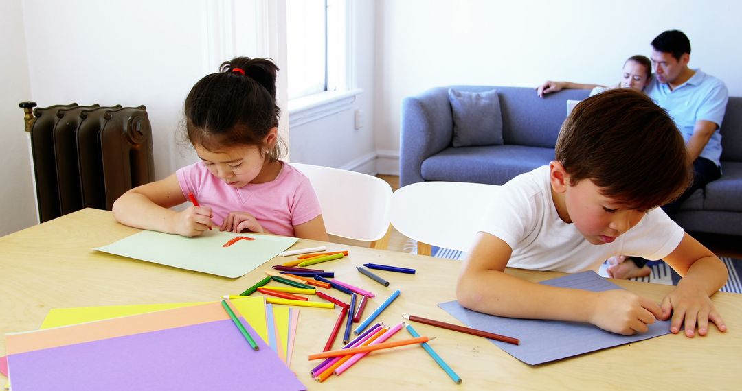 Children Drawing with Crayons While Parents Relax on Sofa - Free Images, Stock Photos and Pictures on Pikwizard.com