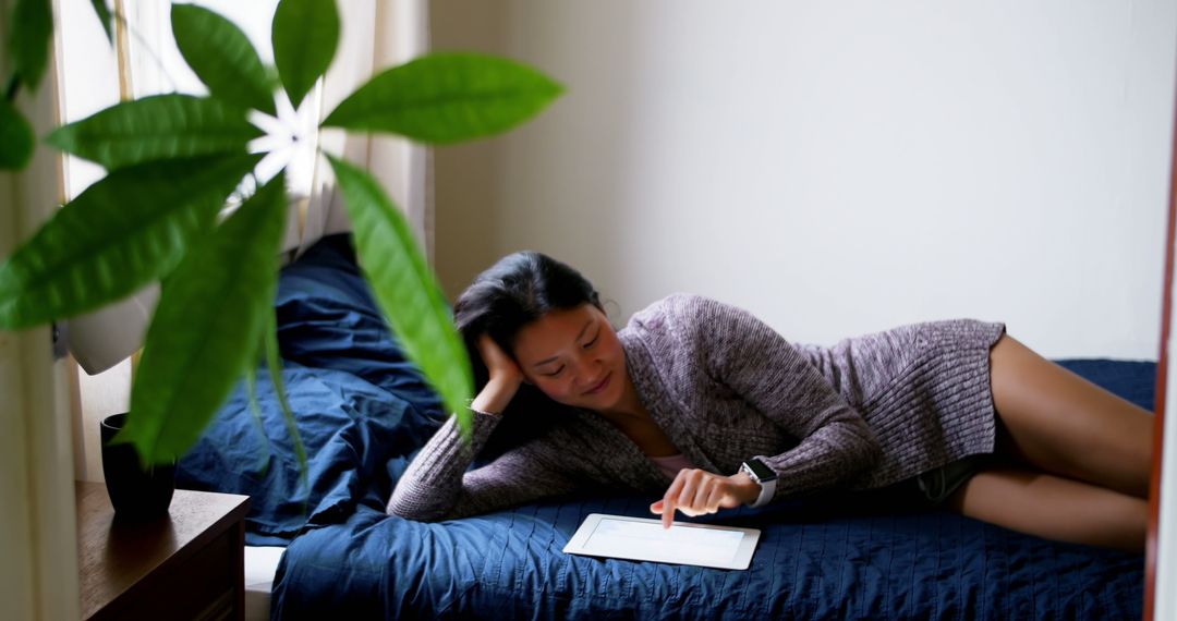 Woman Relaxing on Bed Using Digital Tablet for Online Browsing - Free Images, Stock Photos and Pictures on Pikwizard.com