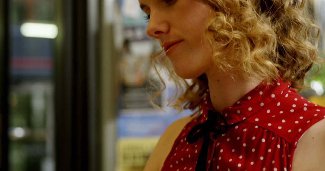 Woman with Curly Hair in Red Polka Dot Shirt Looking Down - Free Images, Stock Photos and Pictures on Pikwizard.com