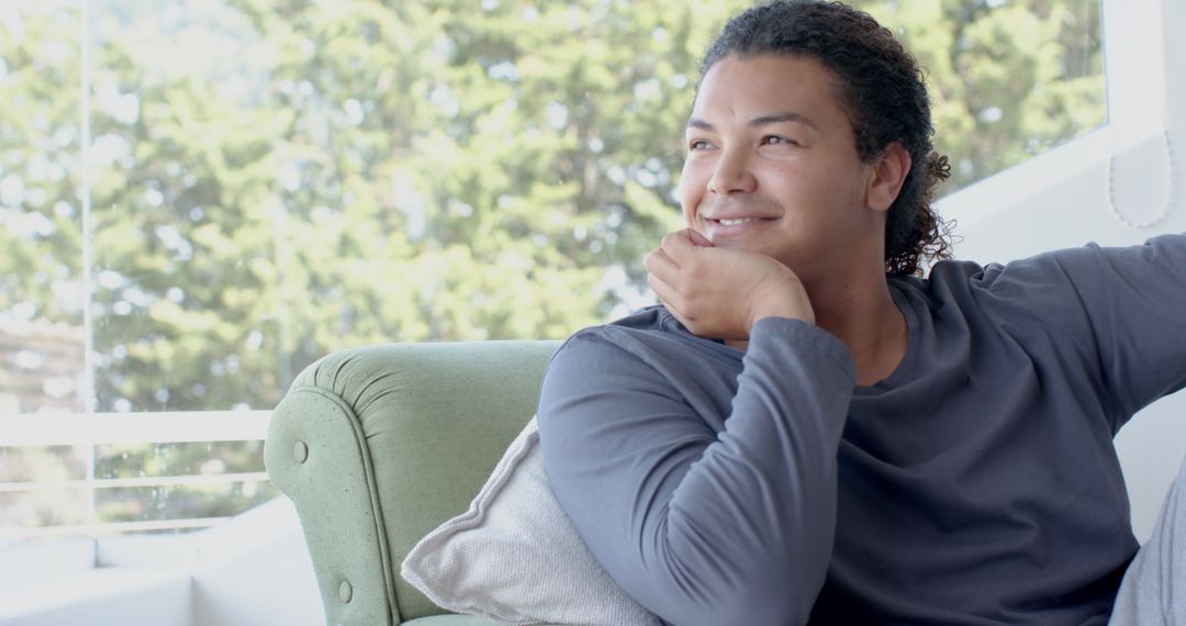 Relaxed Man Smiling at Home Sitting on Couch by Window - Free Images, Stock Photos and Pictures on Pikwizard.com