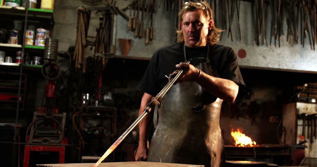 Skilled Blacksmith Using Heated Rod in Traditional Workshop