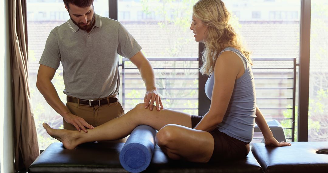 Physical Therapist Treating Female Patient's Leg in Clinic - Free Images, Stock Photos and Pictures on Pikwizard.com