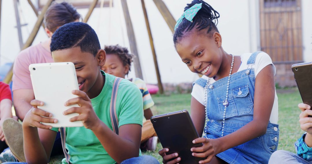 Diverse group of children enjoying tablets in outdoor setting - Free Images, Stock Photos and Pictures on Pikwizard.com