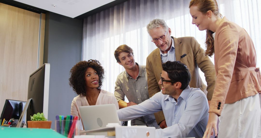 Diverse Team Collaboration around Laptop in Modern Office Setting