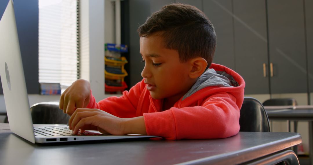 Focused Asian Schoolboy Using Laptop in Class, Learning and Education