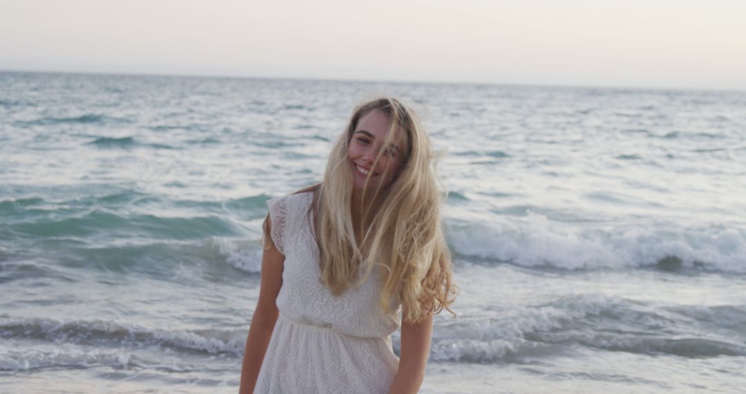 Joyful Young Woman Enjoying Seaside Sunset - Free Images, Stock Photos and Pictures on Pikwizard.com