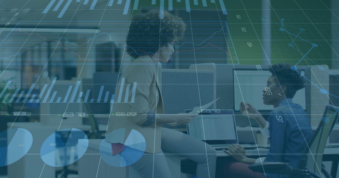 Professional women discussing data visualization and analytics in modern open-plan office