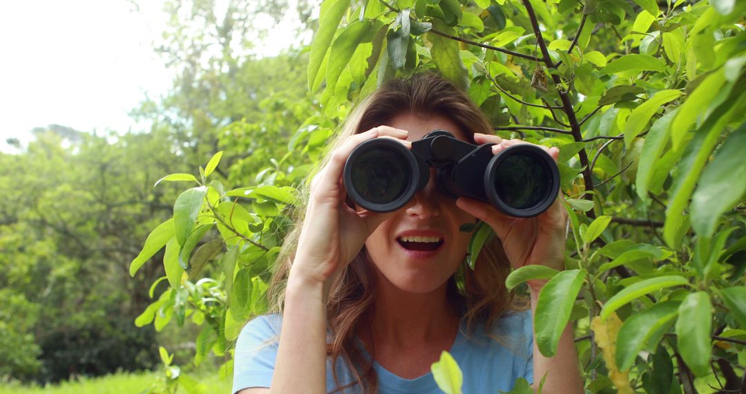 Woman Exploring Nature with Binoculars in Lush Greenery