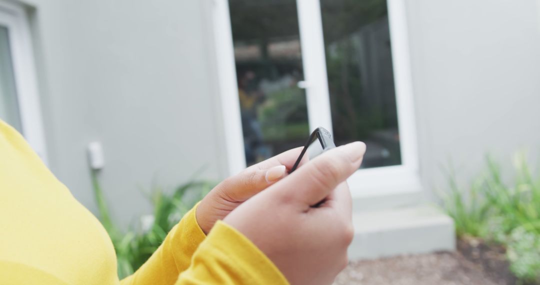 Person Texting on Smartphone Outside Modern House - Free Images, Stock Photos and Pictures on Pikwizard.com