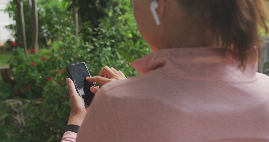 Woman Using Smartphone with Wireless Earbuds Outdoors - Free Images, Stock Photos and Pictures on Pikwizard.com