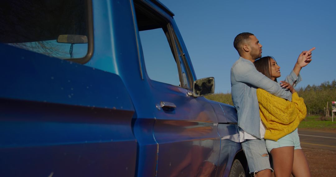 Couple Embracing Beside Blue Truck In Scenic Outdoor Setting - Free Images, Stock Photos and Pictures on Pikwizard.com