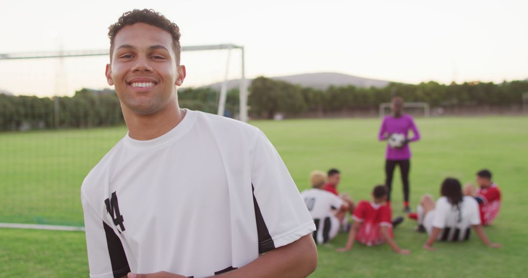 Smiling Young Soccer Player Standing Near Teammates on Field - Free Images, Stock Photos and Pictures on Pikwizard.com