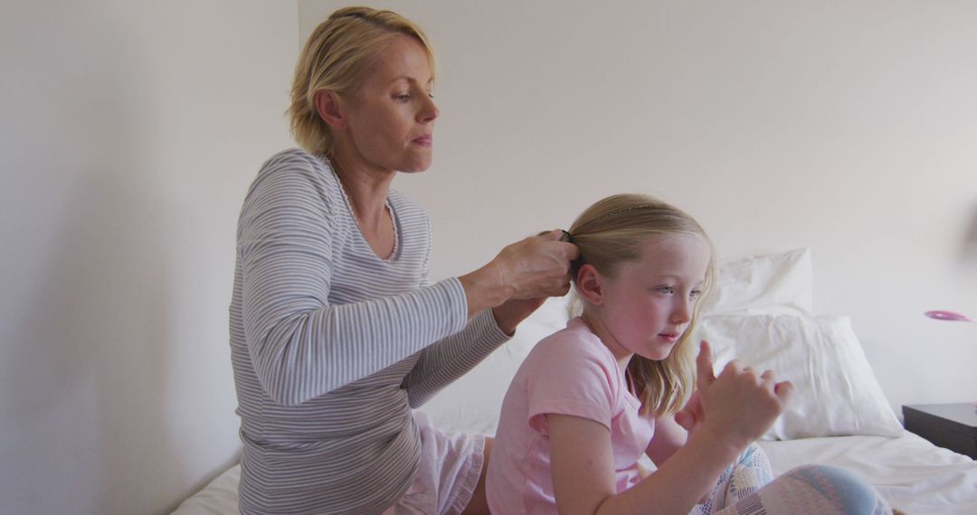 Mother Braiding Daughter's Hair in Bedroom - Free Images, Stock Photos and Pictures on Pikwizard.com