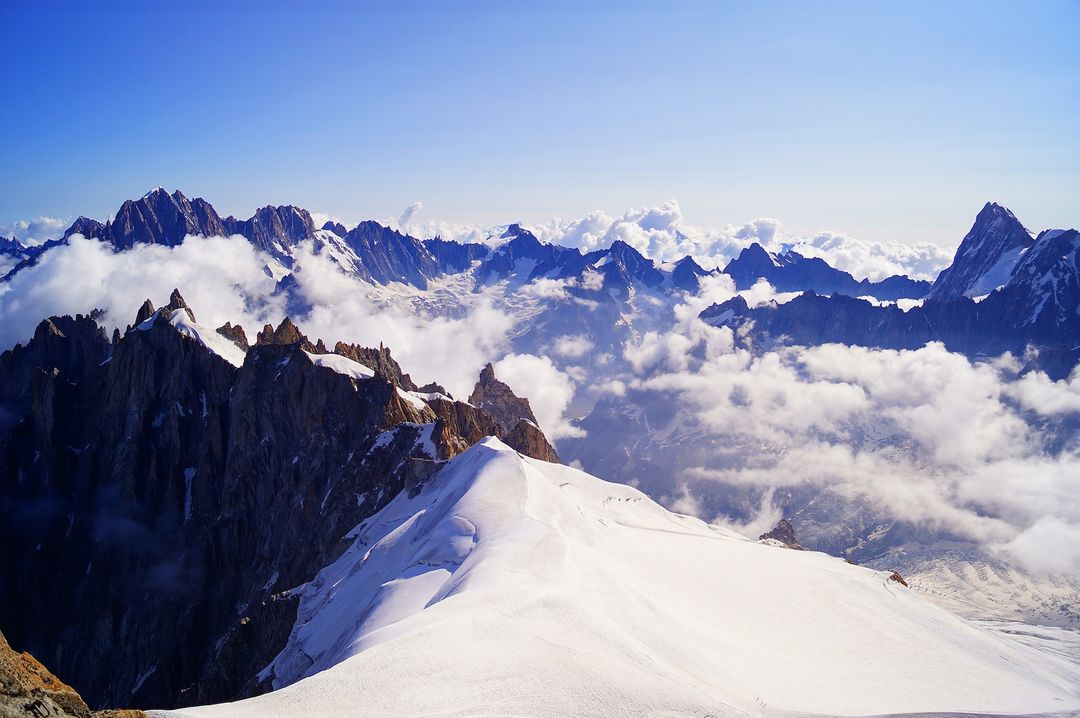 Stunning Snow-Capped Mountain Range with Clouds and Blue Sky - Free Images, Stock Photos and Pictures on Pikwizard.com