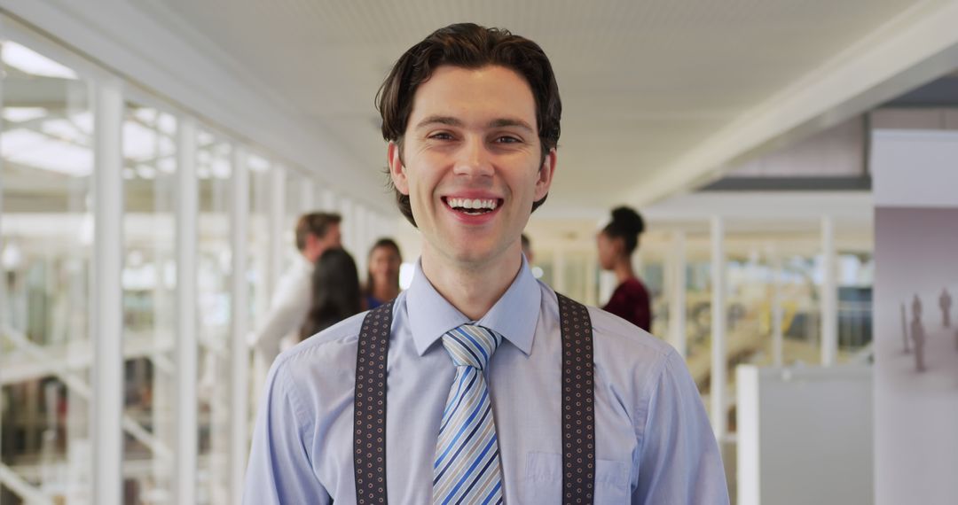 Smiling Young Businessman Wearing Suspenders Standing in Office - Free Images, Stock Photos and Pictures on Pikwizard.com