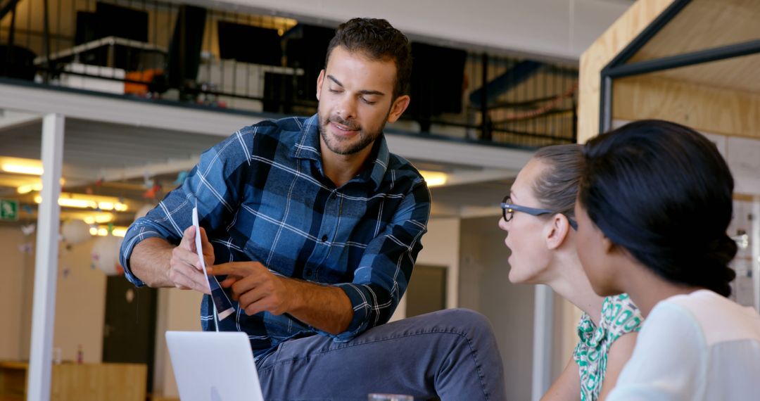 Diverse Team Collaborating in Modern Office Environment with Tech Equipment