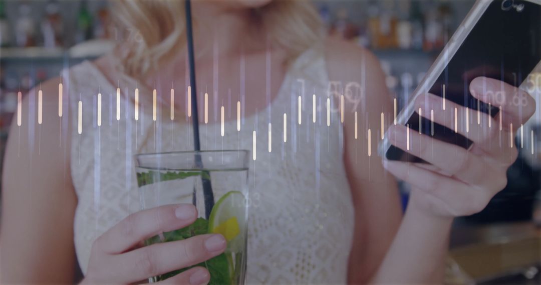 Woman Enjoying Cocktail While Using Smartphone at Bar