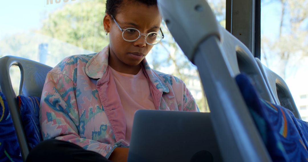 Focused Woman Using Laptop on Public Transit Bus