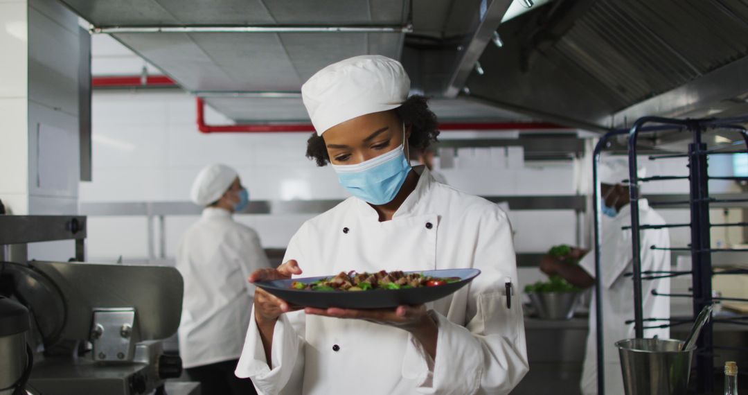 Portrait of african american female chef wearing face mask presenting dish - Free Images, Stock Photos and Pictures on Pikwizard.com