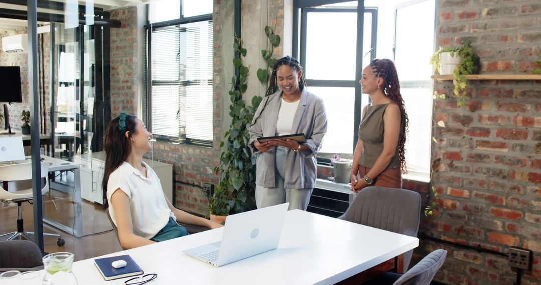 Diverse Female Colleagues Discussing Work in Modern Office Environment