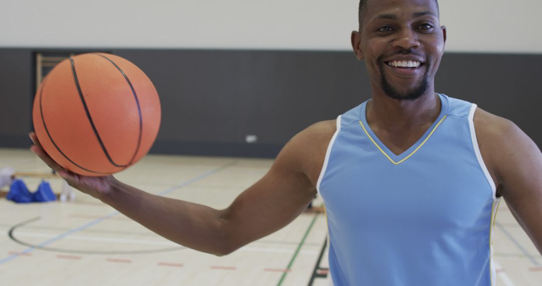 Happy Basketball Player Holding Ball in Indoor Court - Free Images, Stock Photos and Pictures on Pikwizard.com