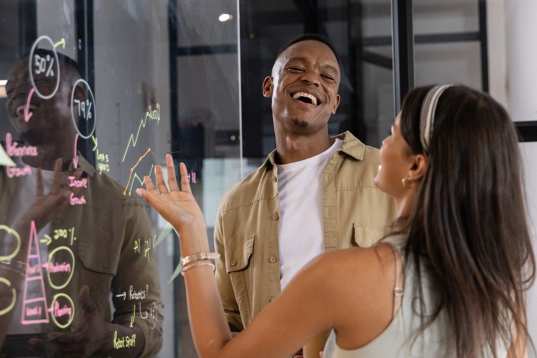 Diverse Coworkers Engaging in Creative Brainstorming at Office Glass Board