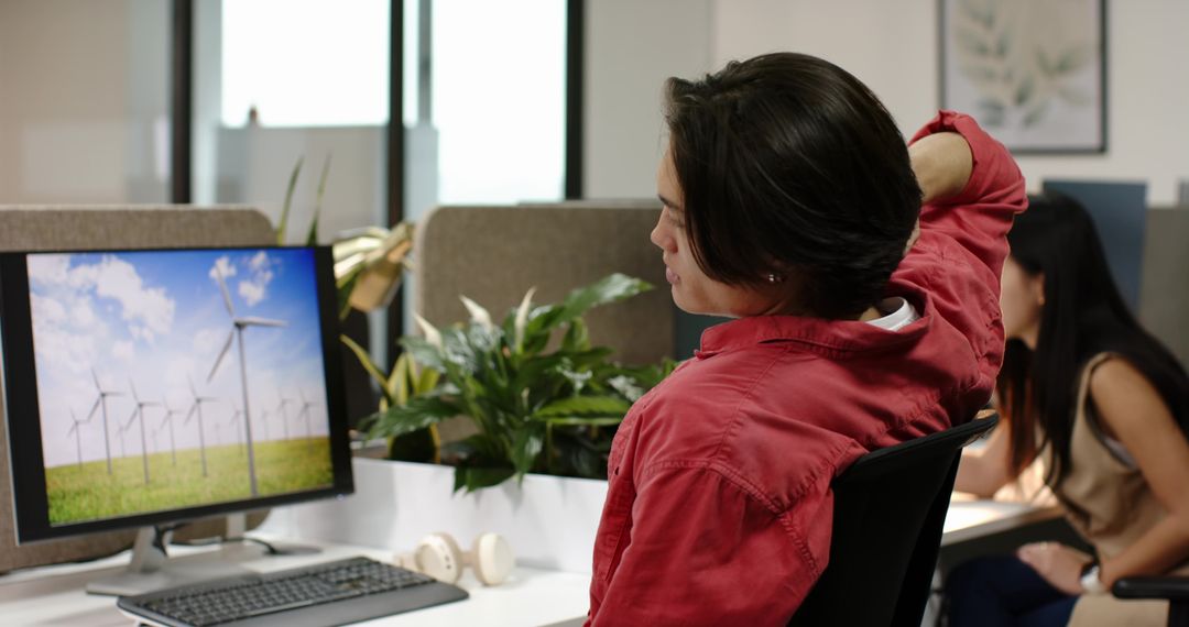 Employee Viewing Wind Turbine Display in Eco-Friendly Office