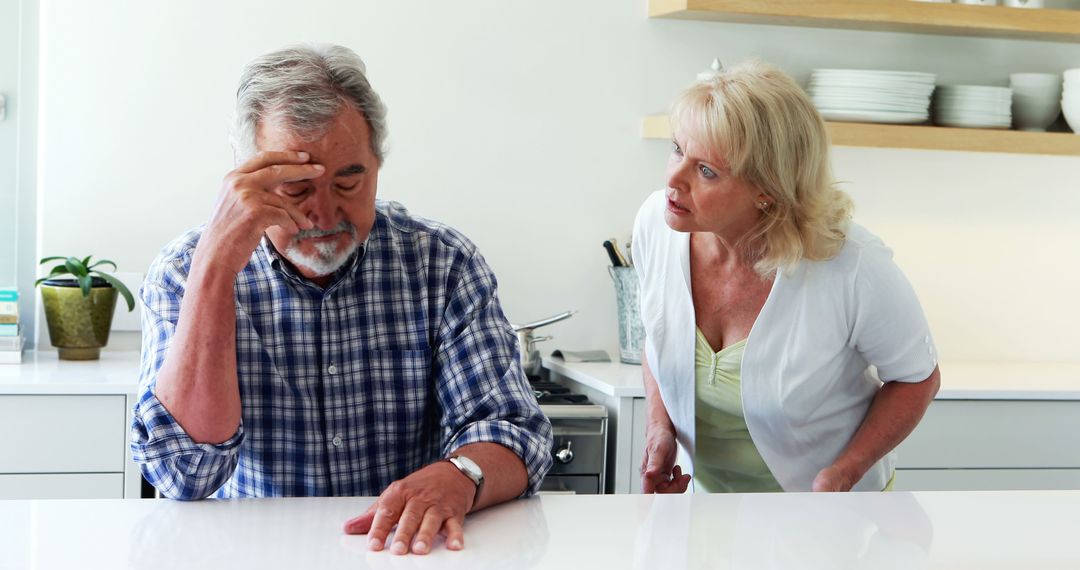 Concerned Woman Comforts Distressed Man in Kitchen Conversation