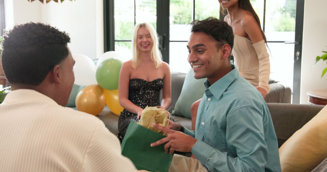 Diverse friends celebrating with gift giving at birthday party