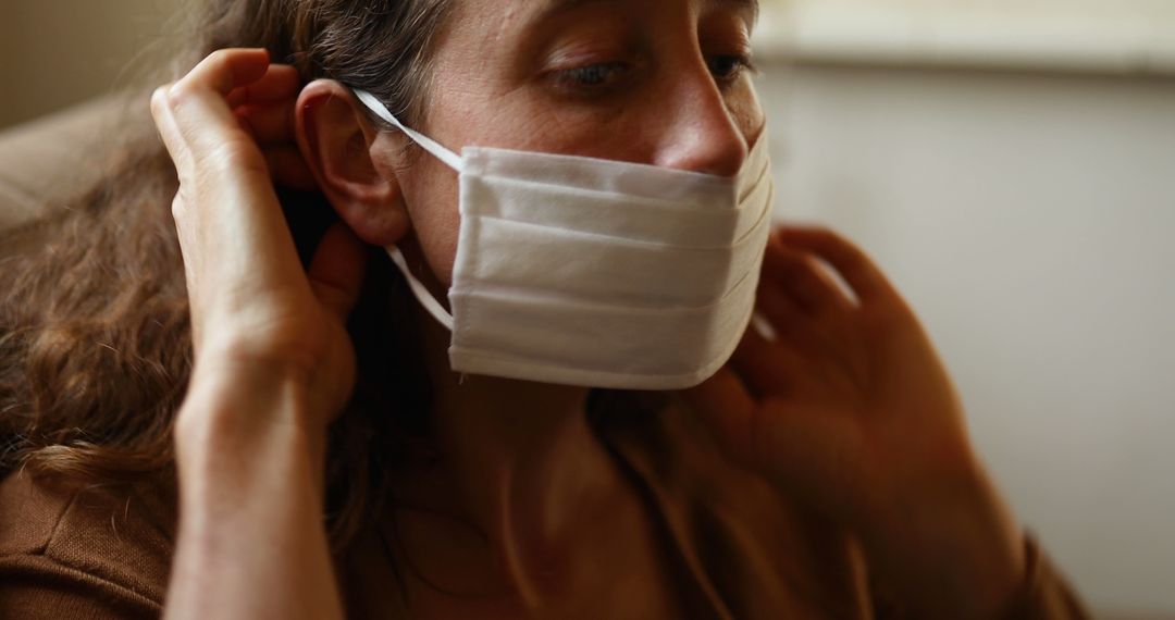 Woman Adjusting White Face Mask for Protection - Free Images, Stock Photos and Pictures on Pikwizard.com