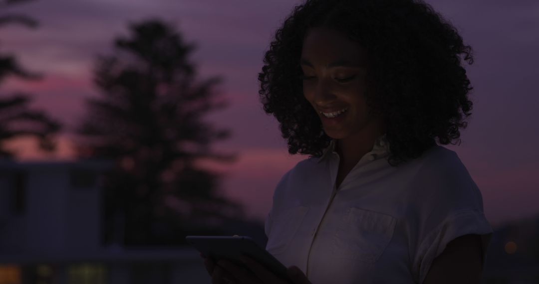 Woman with Digital Tablet Enjoying Sunset in Outdoor Urban Environment - Free Images, Stock Photos and Pictures on Pikwizard.com