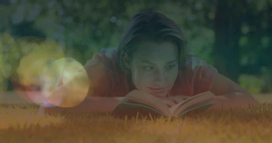Young Woman Relaxing on Lawn While Reading Book