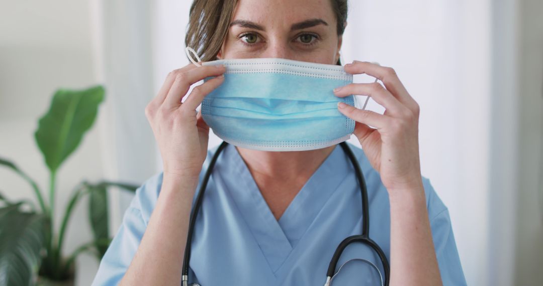 Healthcare Worker Adjusting Surgical Mask in Hospital - Free Images, Stock Photos and Pictures on Pikwizard.com