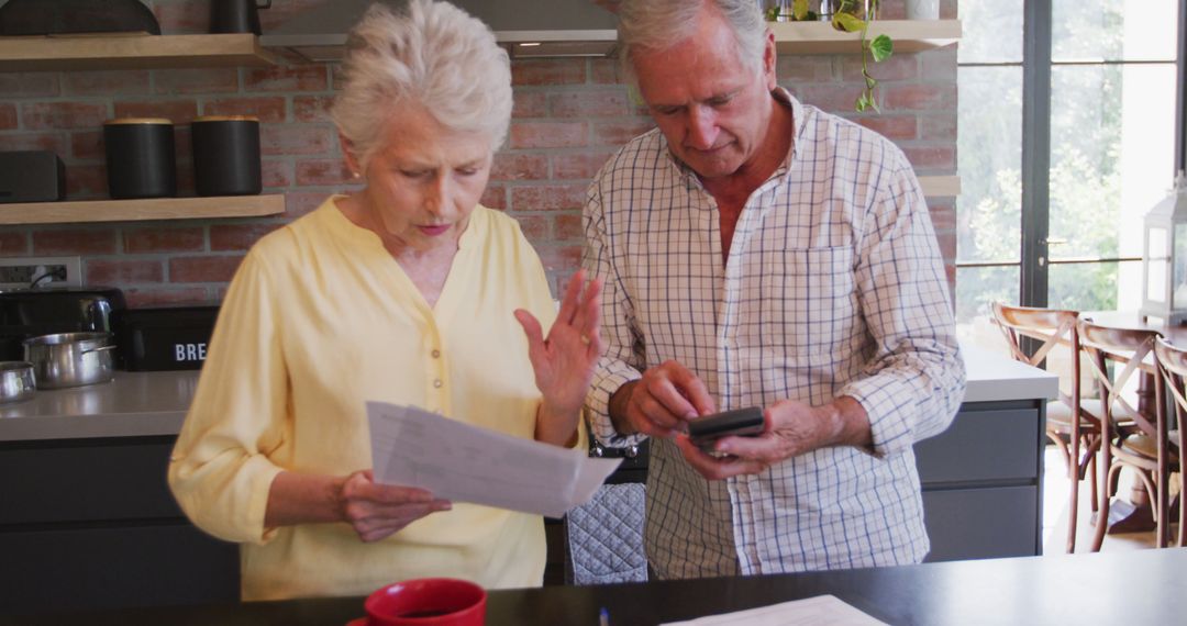 Senior Couple Analyzing Finances in Modern Kitchen - Free Images, Stock Photos and Pictures on Pikwizard.com