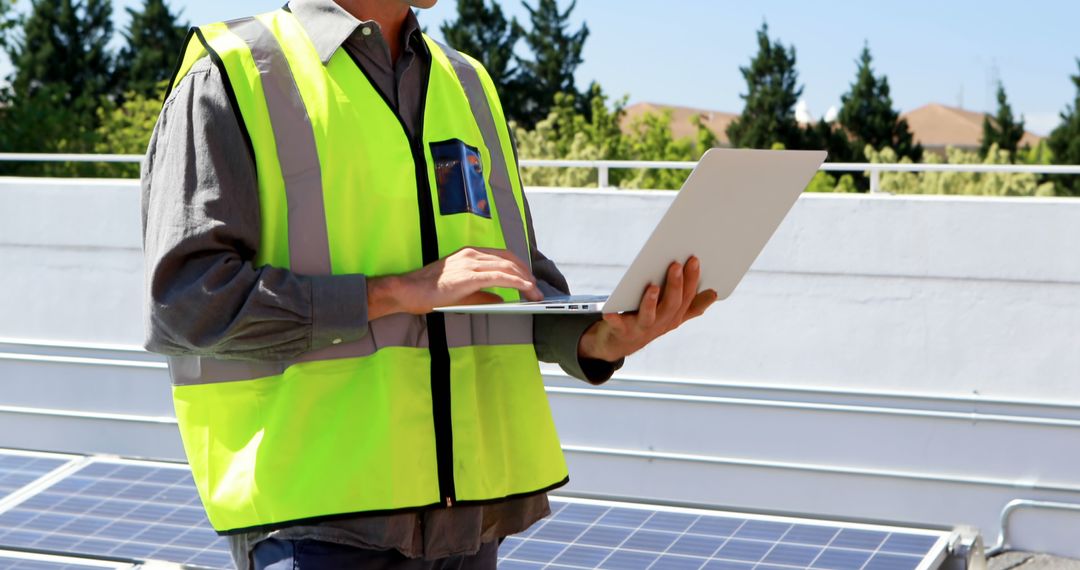 Engineer Inspecting Solar Panels on Rooftop with Laptop - Free Images, Stock Photos and Pictures on Pikwizard.com