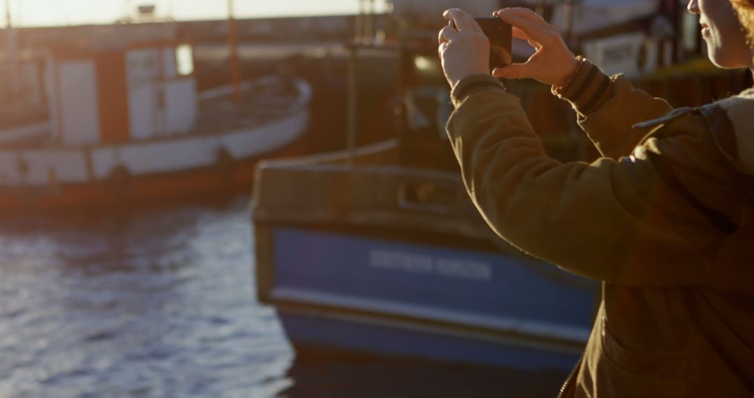 Person Taking Photo of Boats at Sunset in Harbor - Free Images, Stock Photos and Pictures on Pikwizard.com