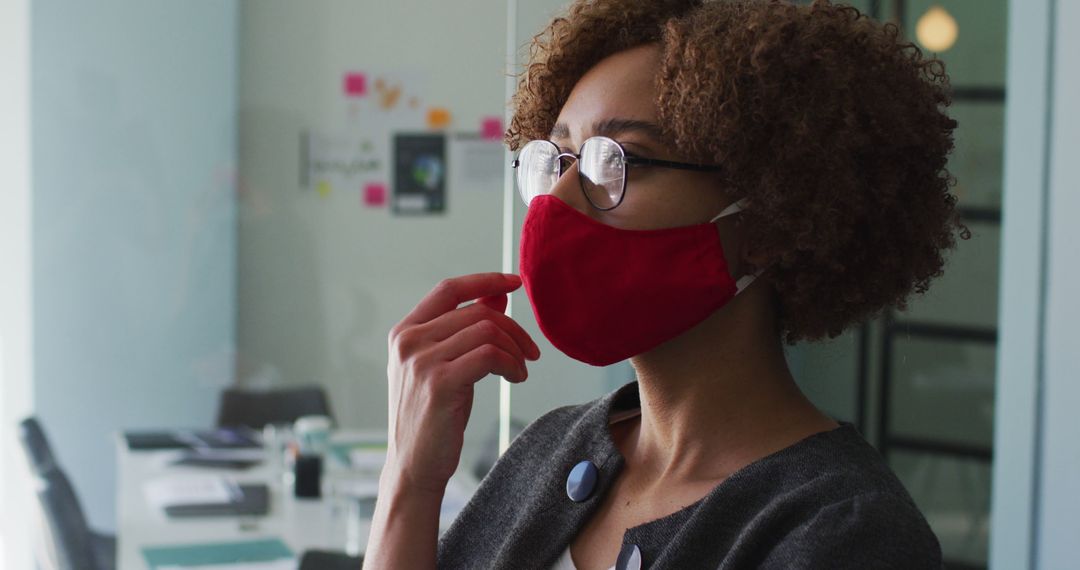 Confident Businesswoman Wearing Red Face Mask in Office - Free Images, Stock Photos and Pictures on Pikwizard.com