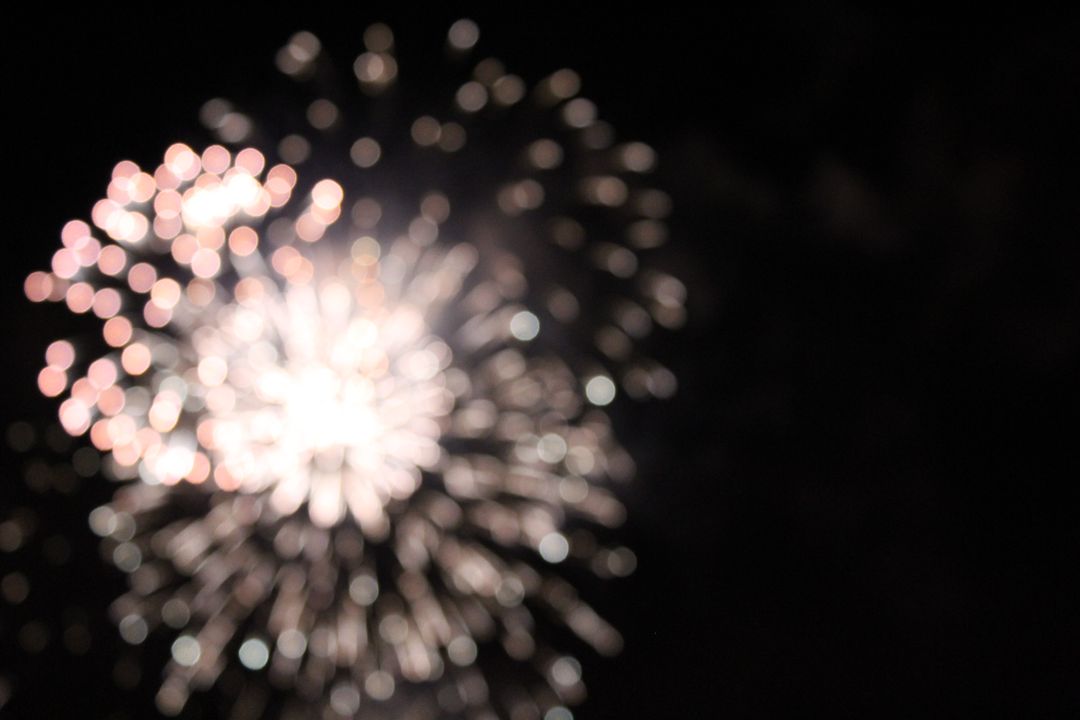 Blurred White and Pink Fireworks Exploding at Night