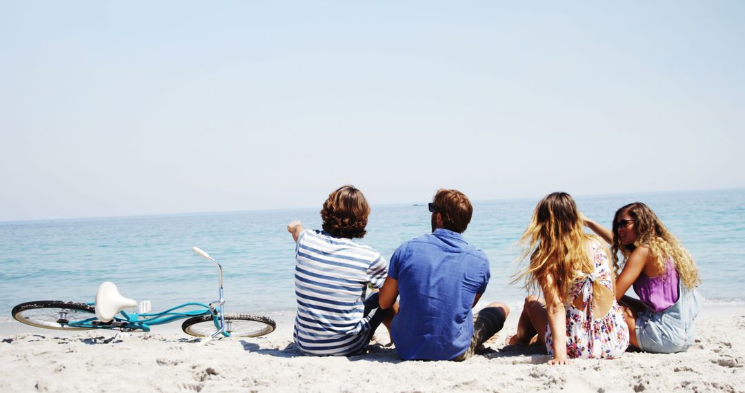 Friends Relaxing on Beach with Bicycle by the Shore - Free Images, Stock Photos and Pictures on Pikwizard.com