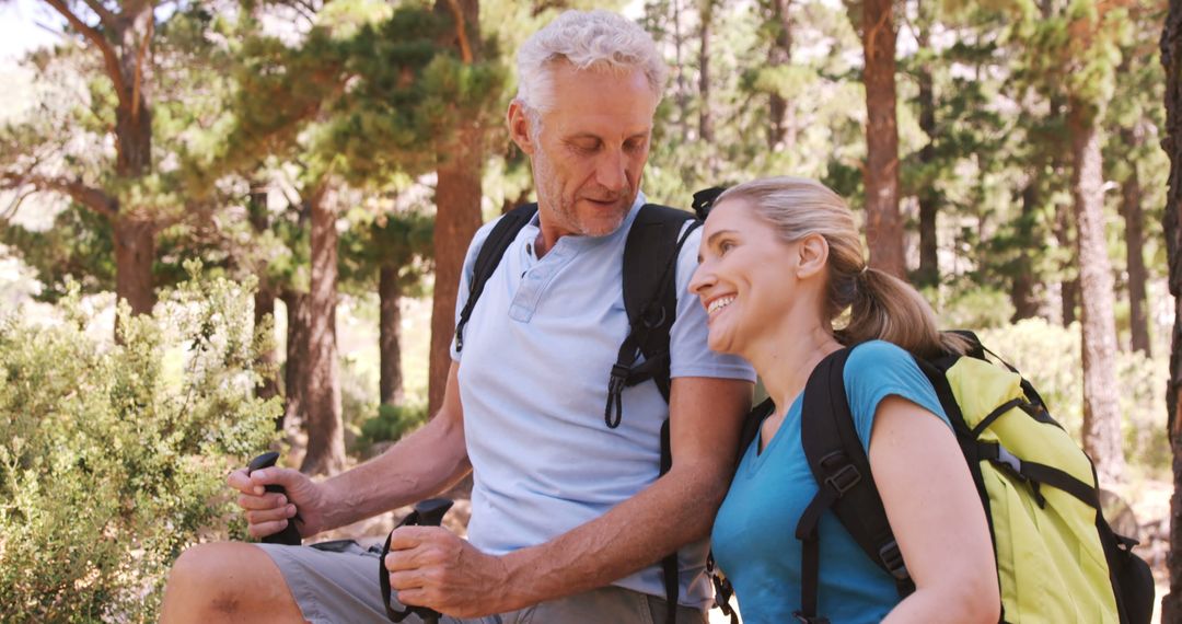 Hiker couple standing with hiking poles in forest - Free Images, Stock Photos and Pictures on Pikwizard.com