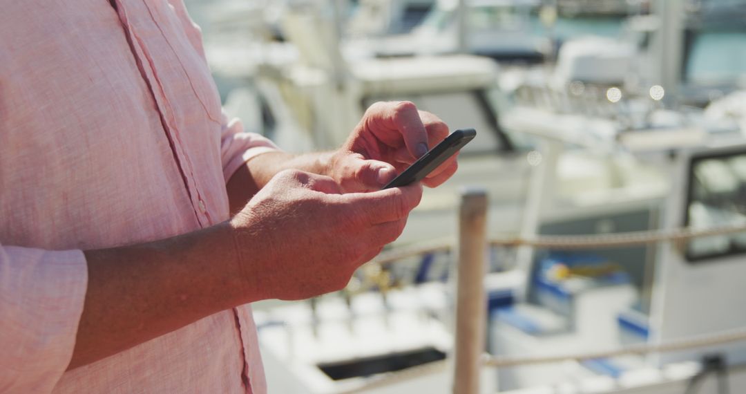 Man Using Smartphone Near Boats at Marina - Free Images, Stock Photos and Pictures on Pikwizard.com