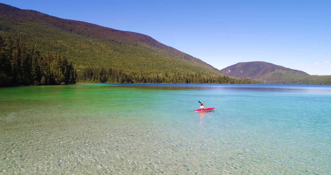Solitary Kayaker Paddling on Crystal Clear Mountain Lake - Free Images, Stock Photos and Pictures on Pikwizard.com